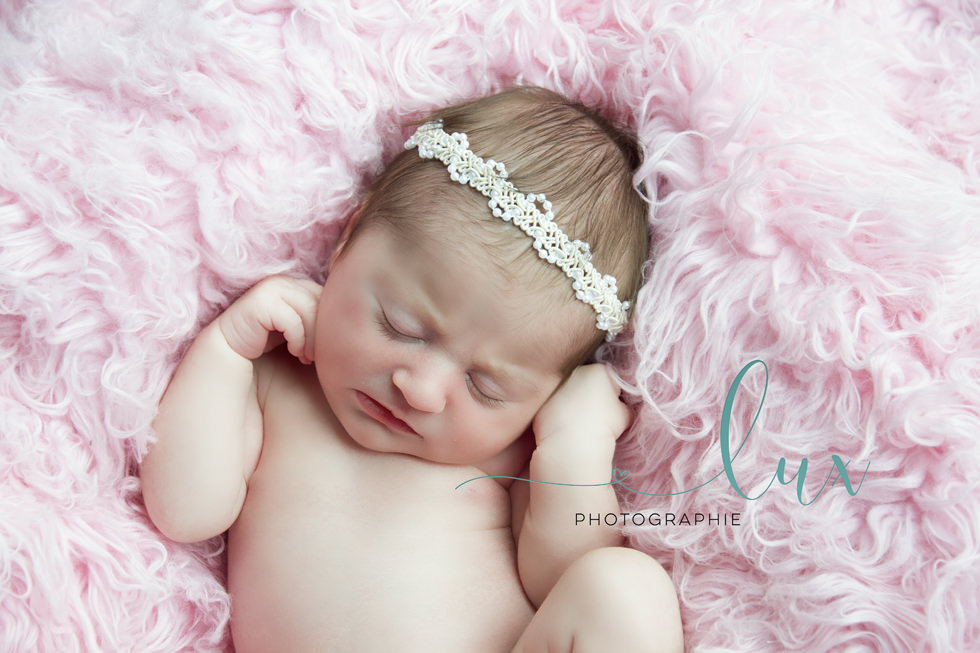 Newborn Photography West-Island. Newborn baby sleeping on pink fur.