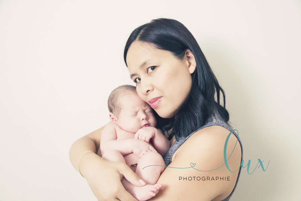 Montreal baby photography. Mother holding newborn baby.