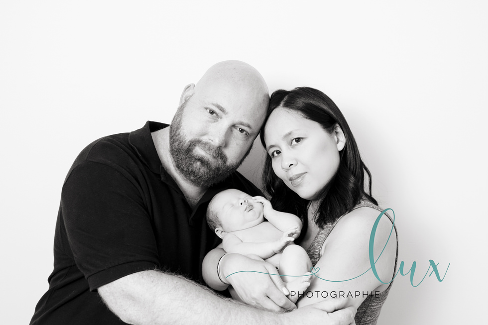 Montreal baby photography. Mother and father holding newborn baby.
