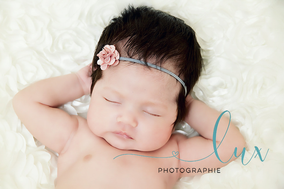 Newborn Photography Laval. Newborn baby girl sleeping with her hands behind her head.