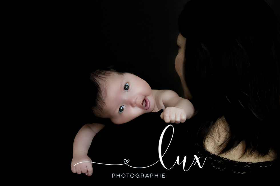 Laval Newborn Photographer. Baby looking over mother's shoulder