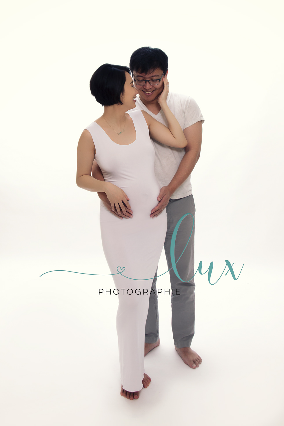 Montreal maternity photographer. Man and pregnant woman laughing.