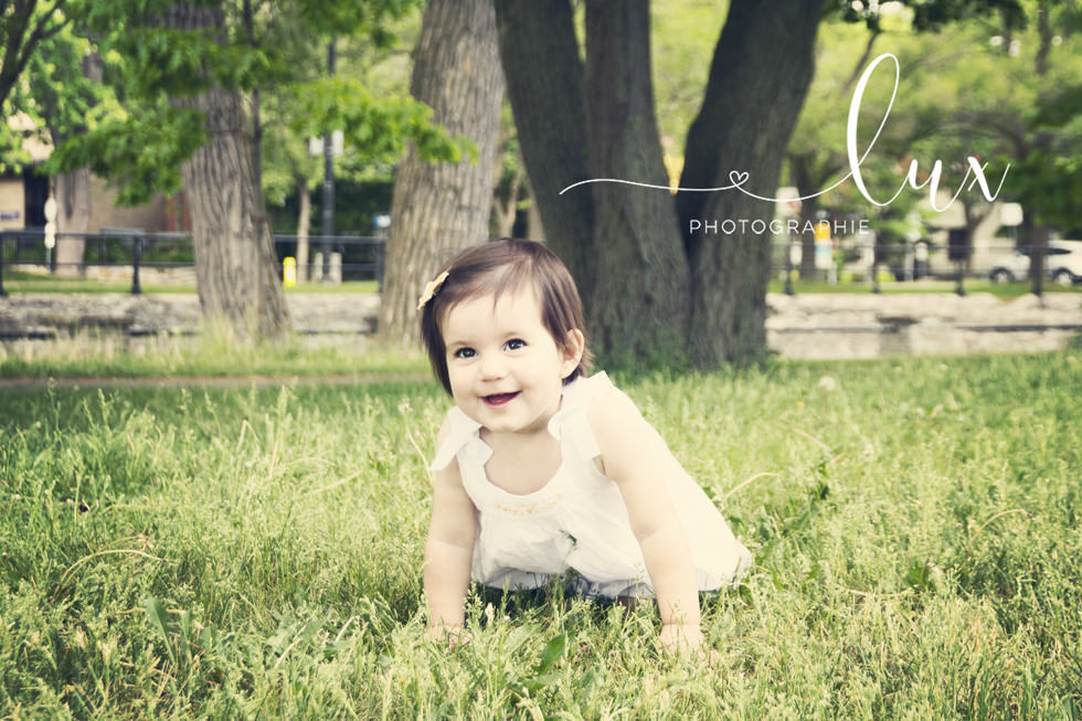 Family photographer Montreal. Baby girl crawling in the grass.