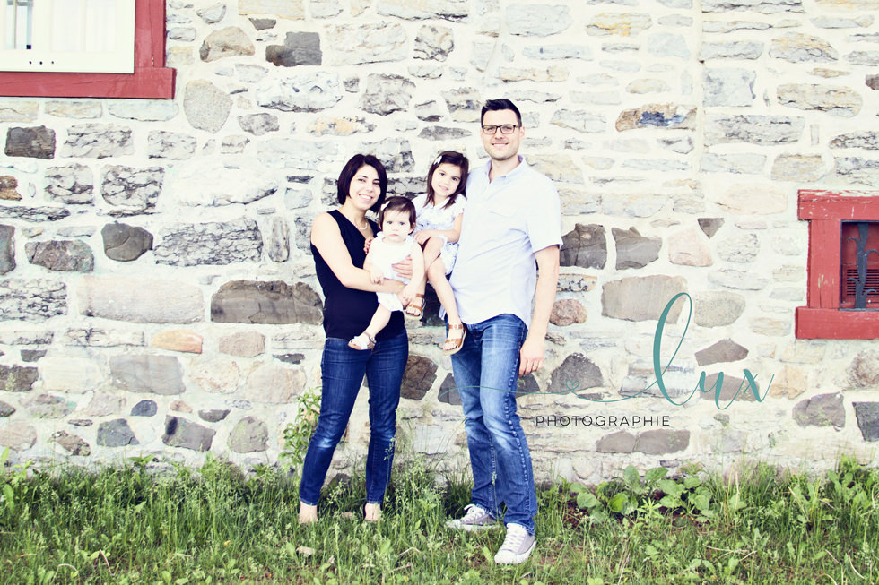 Family photographer montreal. Family standing in front of stone building.