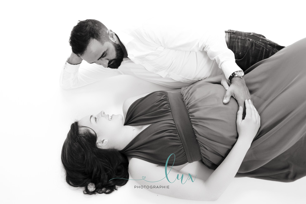 Pregnancy Photography Montreal. Man and pregnant woman lying on the floor.