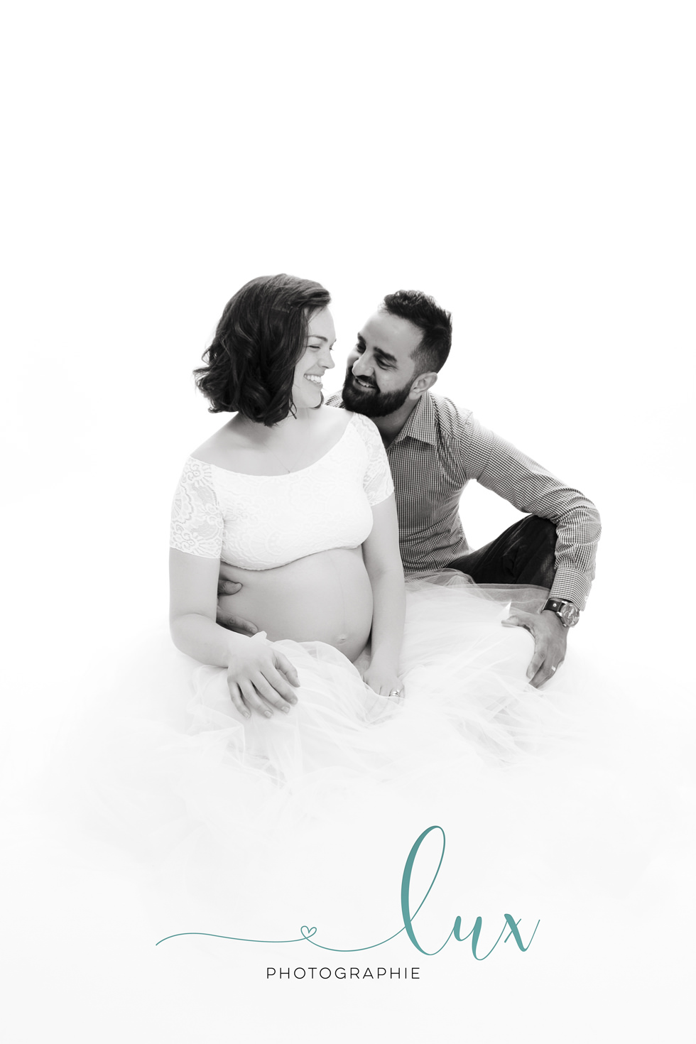 Pregnancy Photography Montreal. Pregnant woman in tutu sitting with husband on the floor.