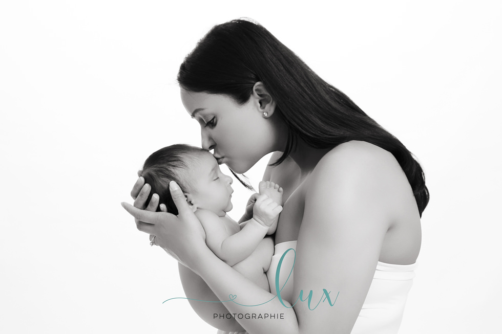 Baby photography Montreal. Mother kissing baby's forehead. 