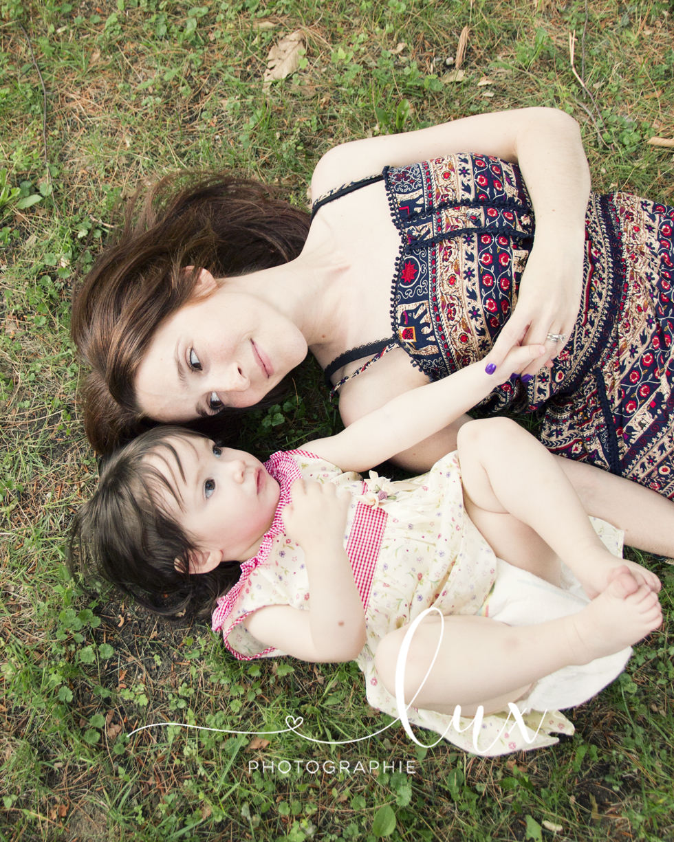Family Photography. Mother and daughter lying in the grass.