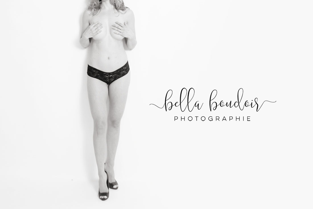 Boudoir photography Montreal. Woman standing and covering breasts.