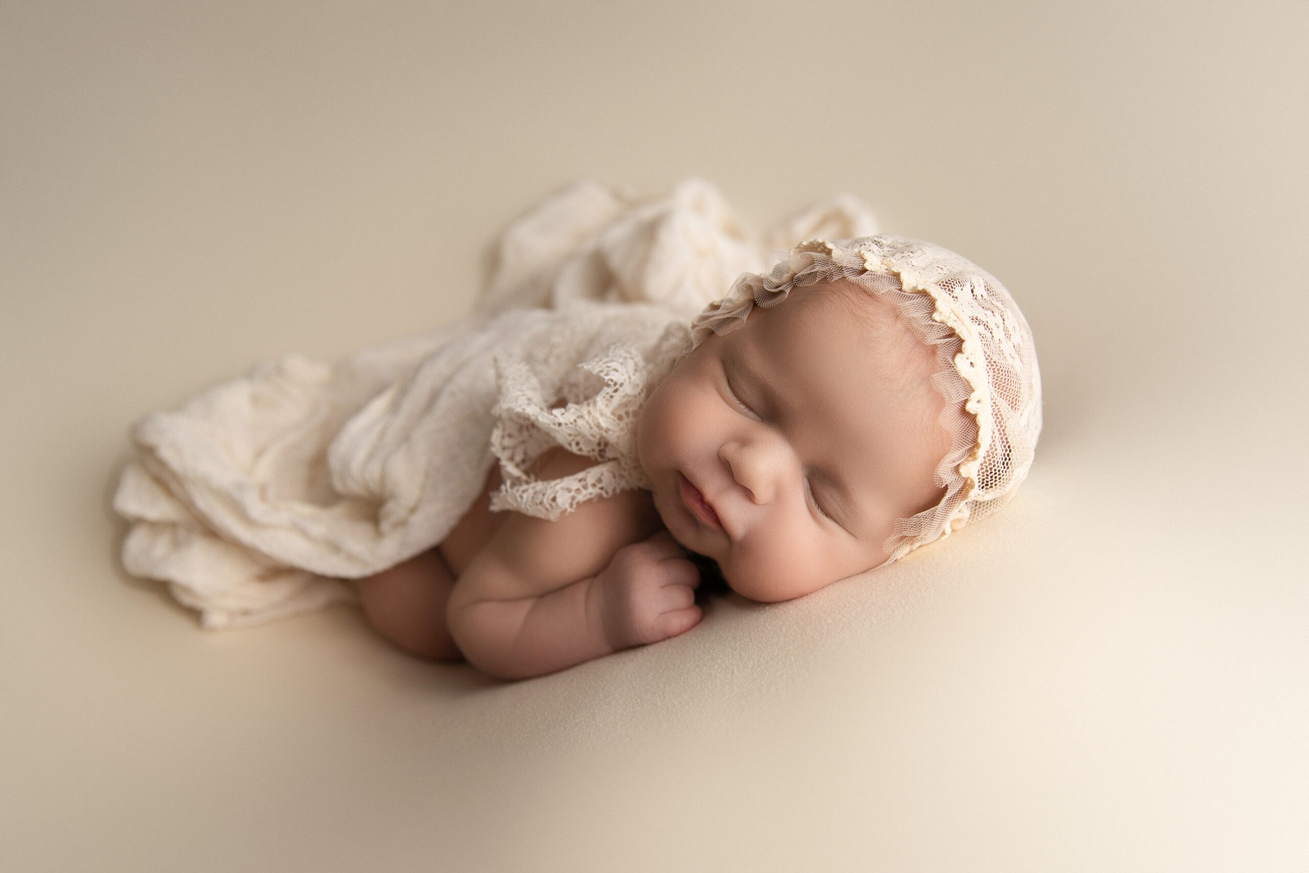 Newborn Photography Montreal. Newborn lying on a cream backdrop