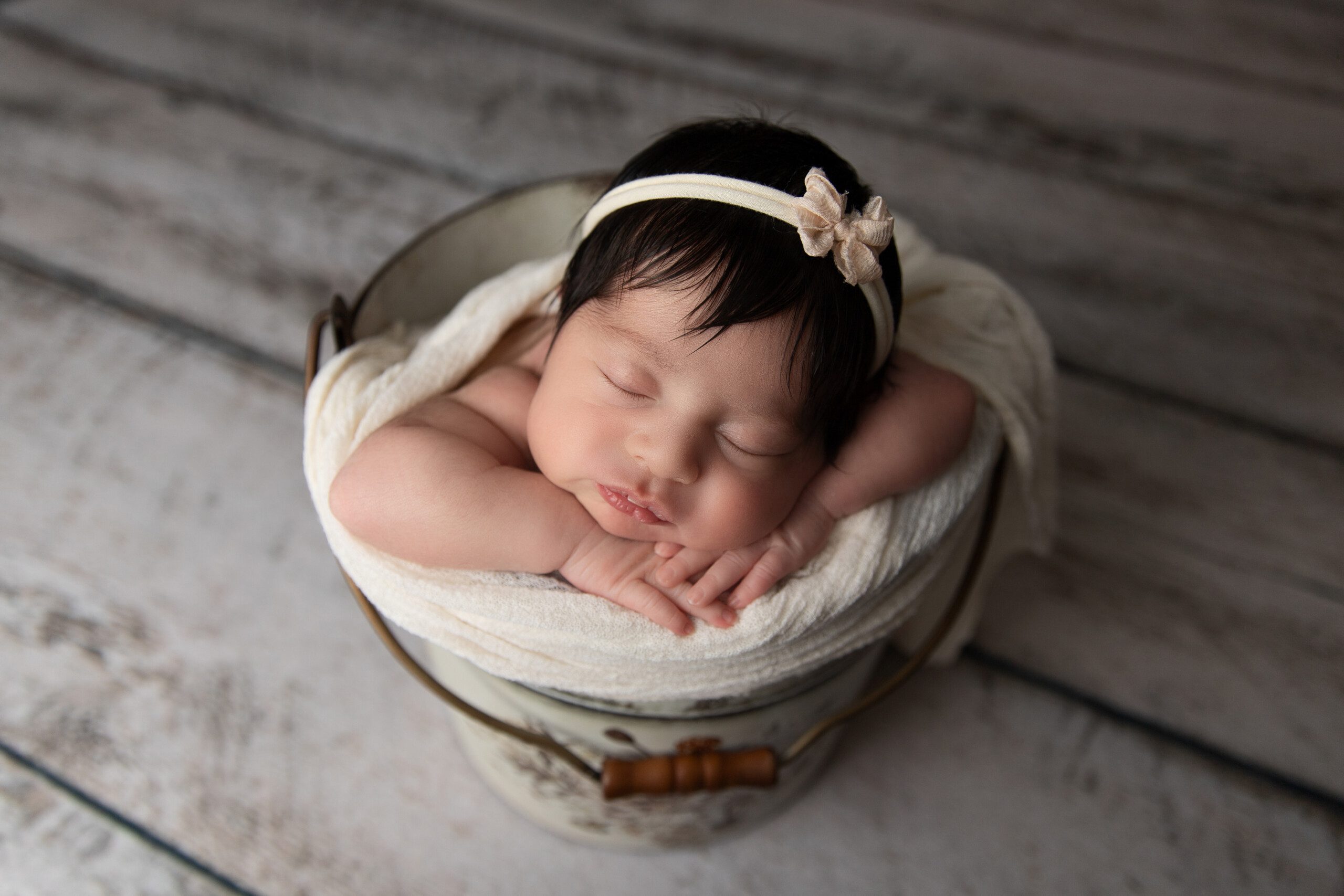 Photographe Nouveau-Né Montreal. Baby girl posing in a bucket.